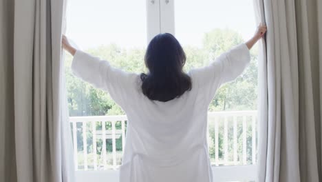 Mujer-Asiática-Feliz-Abriendo-Cortinas-En-El-Dormitorio,-En-Cámara-Lenta