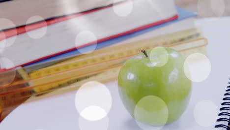 animation of white spots over apple and books