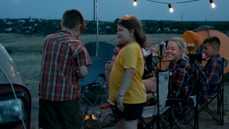 people with children playing charades in campsite