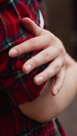 self hugging woman on cottage terrace closeup. frozen lady in red checkered shirt warms with self embracing on cold autumn day. model crosses arms