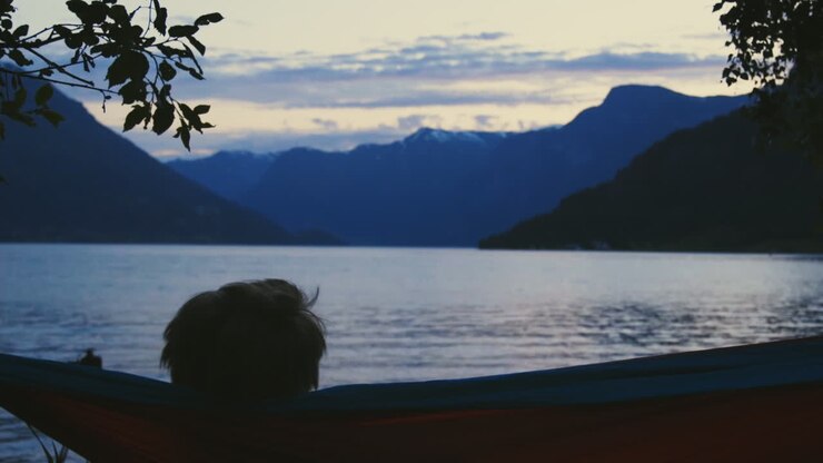 Silhouette of young man enjoying a sunset from his hammock