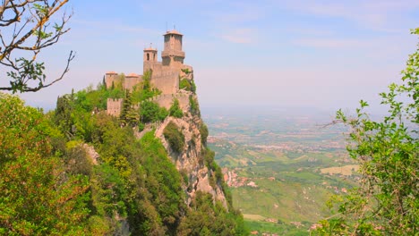 dense foliage at mount titano with the three towers of san marino in italy