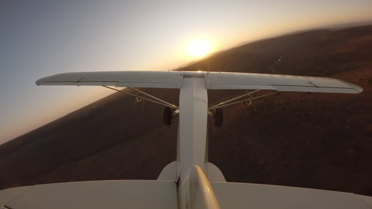 Aereo leggero sopra colline ondulate al tramonto nella savana
