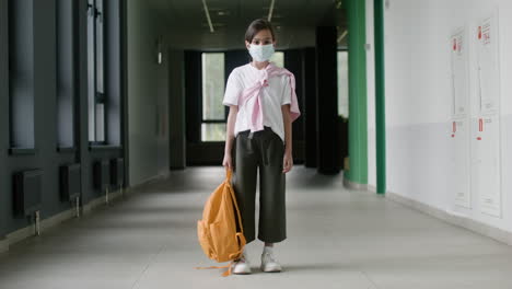 schoolgirl with face mask in school corridor.