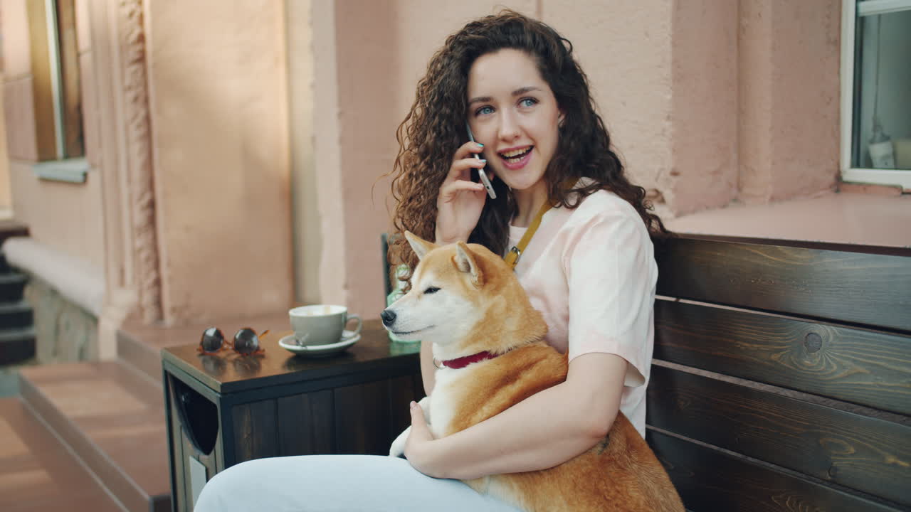 Woman with her dog enjoying a coffee break outside a cafe.