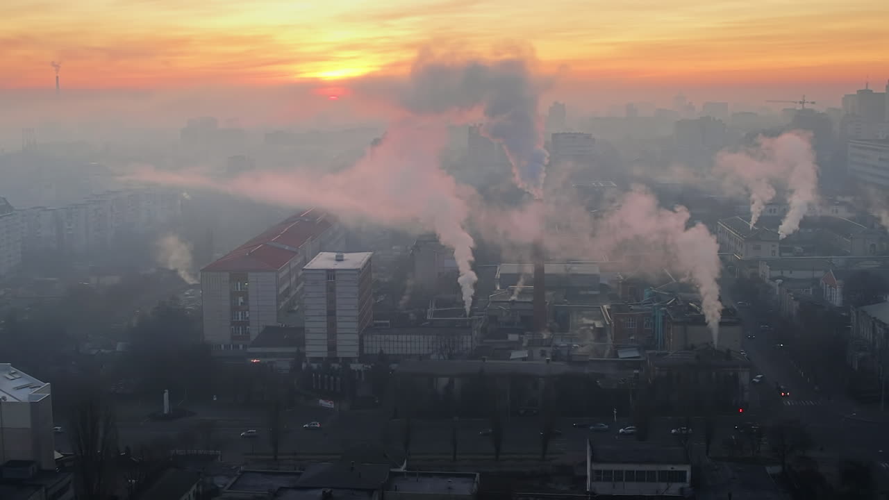 Aerial drone view of an production facility in Chisinau at sunrise, Moldova. Cityscape with multiple buildings, pipes with felling steam