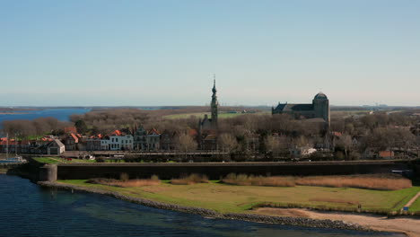 Aerial:-The-historical-town-of-Veere-with-an-old-harbour-and-churches,-on-a-spring-day