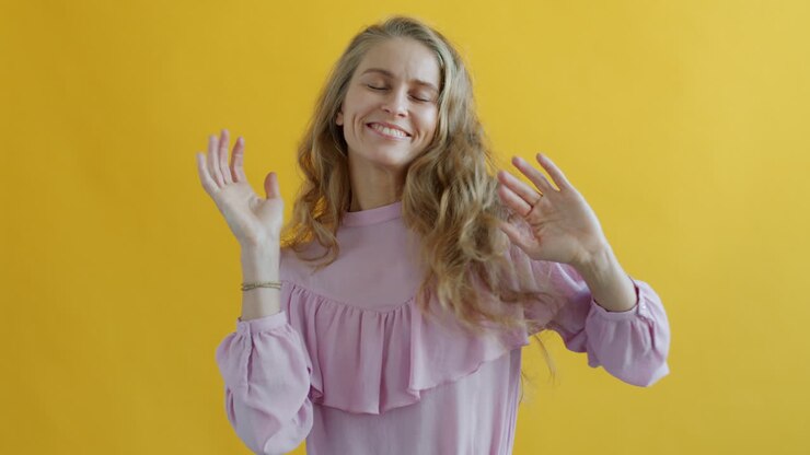 Donna che balla davanti a uno sfondo giallo