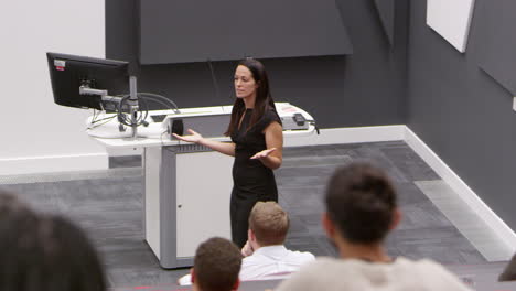 Back-row-student-POV-of-female-teacher-in-lecture-theatre,-shot-on-R3D