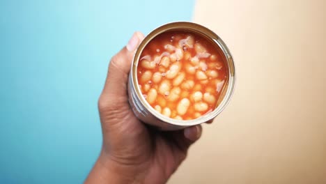 hand holding a can of baked beans