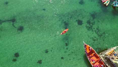 Drones-Aéreos-Vuelan-Sobre-El-Kayak-De-Mar-Remando-En-Aguas-Transparentes-De-La-Playa-De-Pejerrey,-Chile,-Gente-Disfrutando-De-Deportes-Acuáticos-En-Un-Destino-Prístino-Turquesa