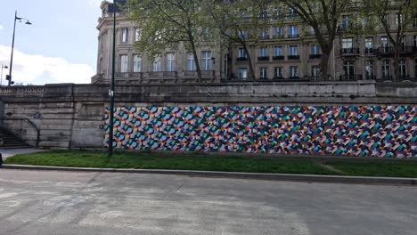 pedestrians pass a vibrant mural in paris