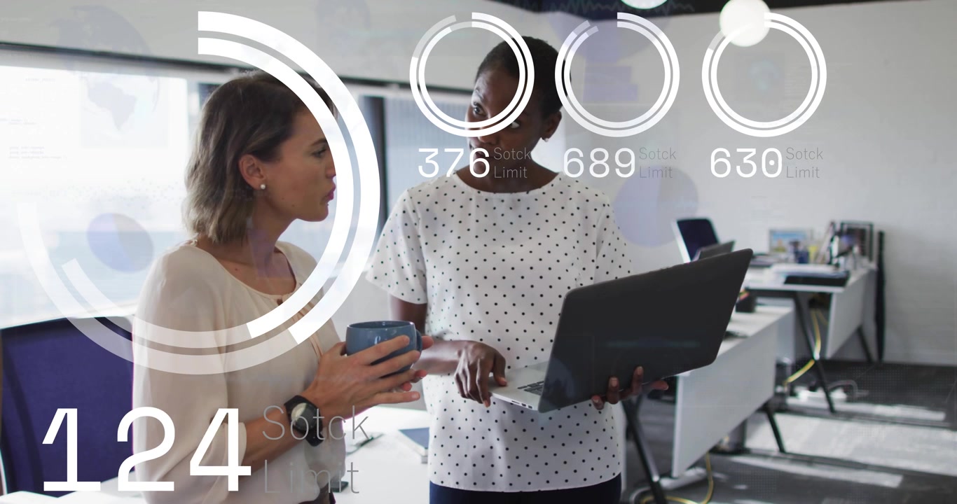 Two women in office, animated business metrics appearing and rising, pointing and reviewing laptop