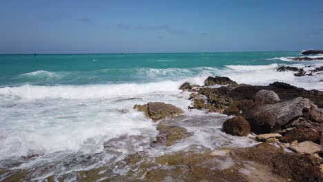 agua turquesa del caribe chocando contra las rocas a lo largo de la costa de la isla