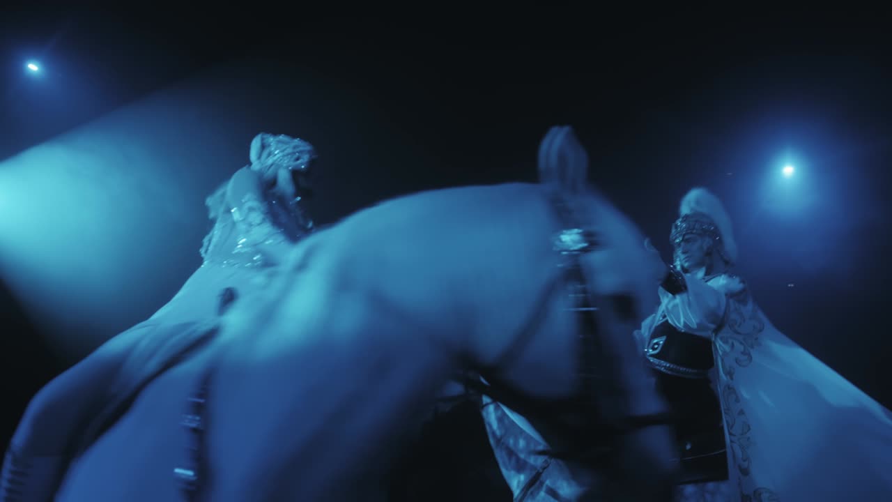 una chica y un hombre a caballo se mueven en círculo con una bufanda en las manos en una hermosa iluminación, una actuación de circo