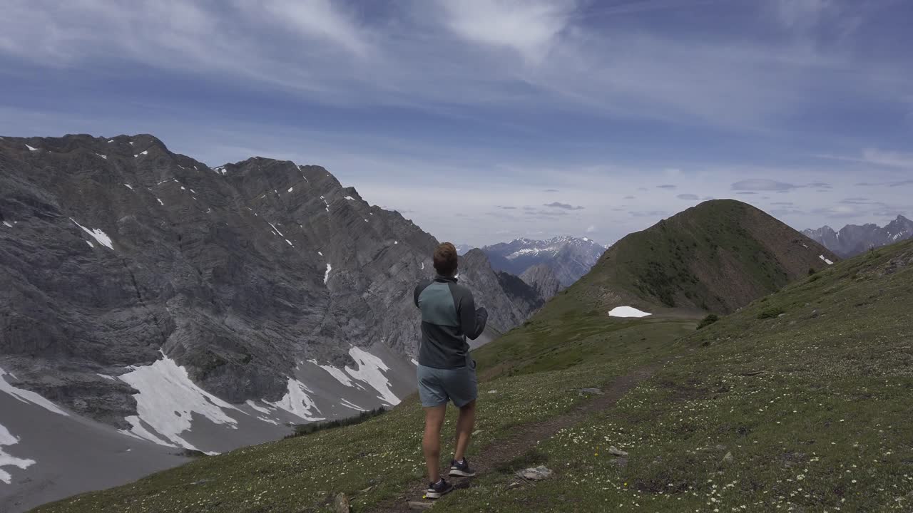 caminante en la pradera de montaña caminando agua potable rockies kananaskis alberta canada
