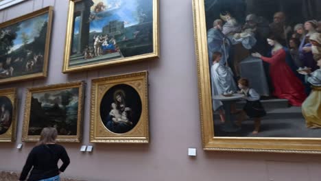 visitors admire paintings in the louvre museum