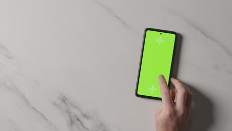 Overhead-Studio-Shot-Of-Man-Using-Green-Screen-Mobile-Phone