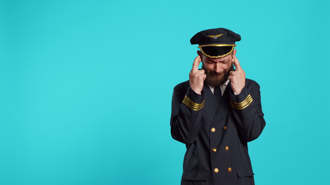 Pilota di aeroplano fiducioso che posa incrociando le dita