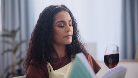 mujer disfrutando de un vaso de vino y leyendo un libro de recetas