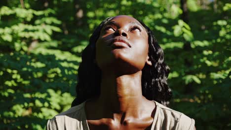 A contemplative scene of an African American woman looking upward amidst lush greenery