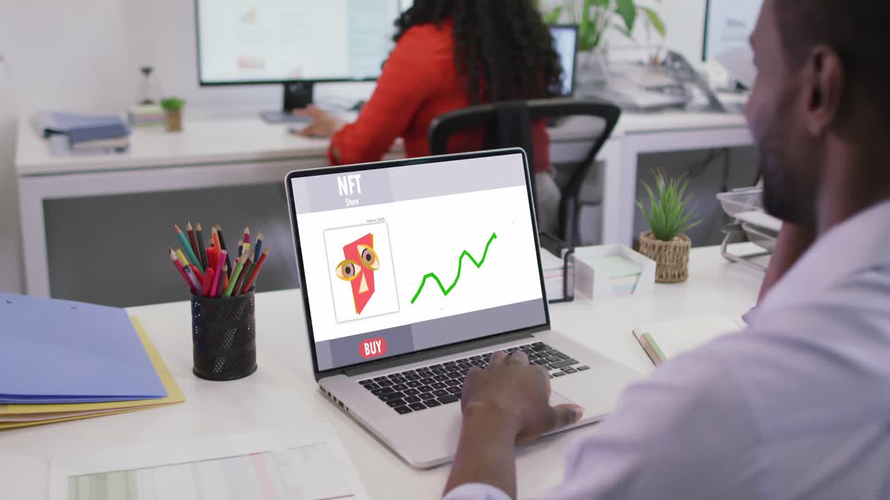 video de un hombre afroamericano trabajando en una computadora portátil con nft en la pantalla