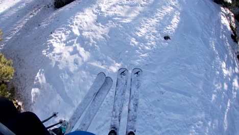 first person view pov of two people riding on a chair lift with skis covered with snow