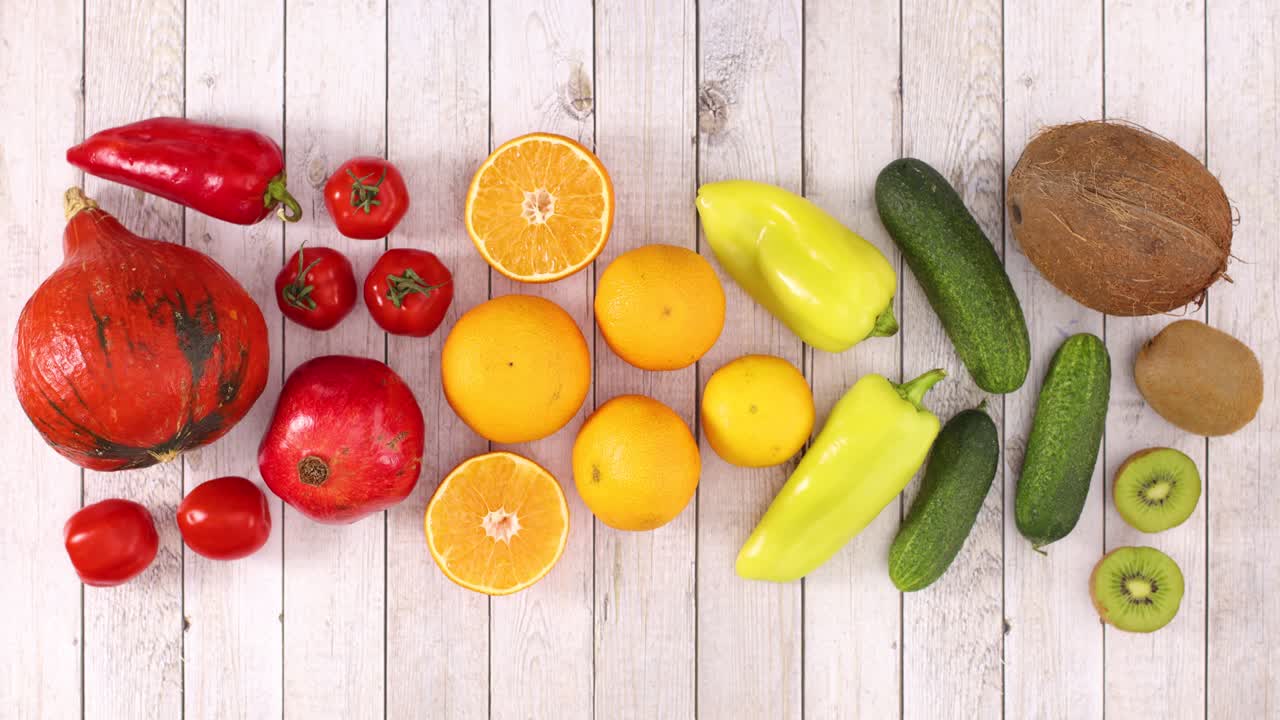 rojas, naranjas, amarillas y verdes frutas y verduras se mueven en el tema de madera. detener el movimiento