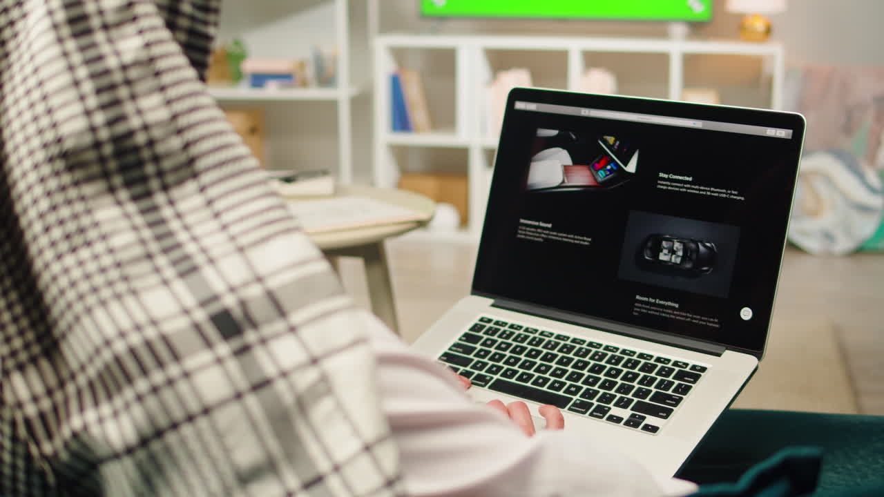 BARCELONA, SPAIN, 22 APRIL, 2022: Middle eastern man using laptop close-up. Tesla website, buying a tesla car online