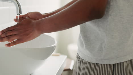 black man cleaning hands with soap water
