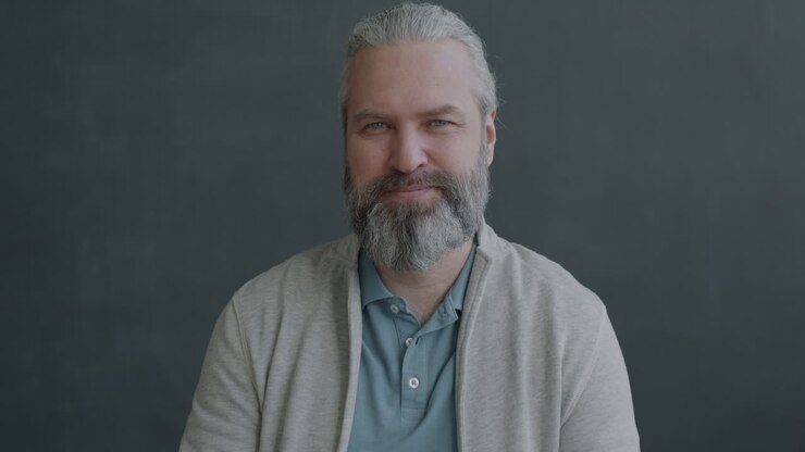 Smilende mann som gir tommel opp