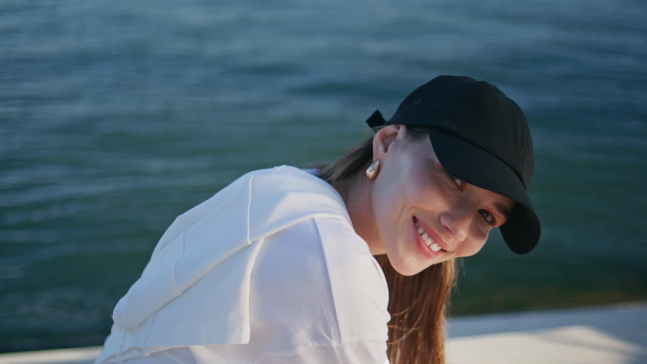 Woman tourist sitting waterfront enjoying summer day closeup portrait