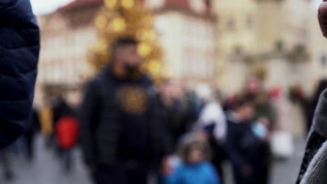 plastic cups with hot wine clinking in front of christmas tree in prague, extreme closeup view