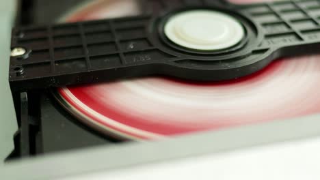 a detailed view of a disc being loaded into a cd player highlighting technology in a home setting.