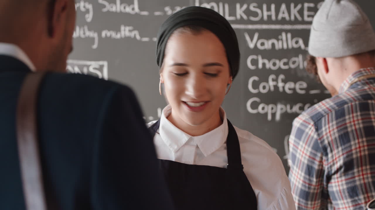 happy barista woman serving customer making payment using smart watch buying coffee spending money in cafe