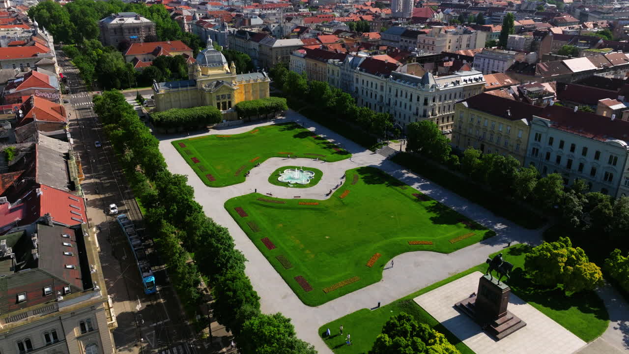 el tranvía pasa por la plaza del rey tomislav, un parque de la ciudad en zagreb, croacia