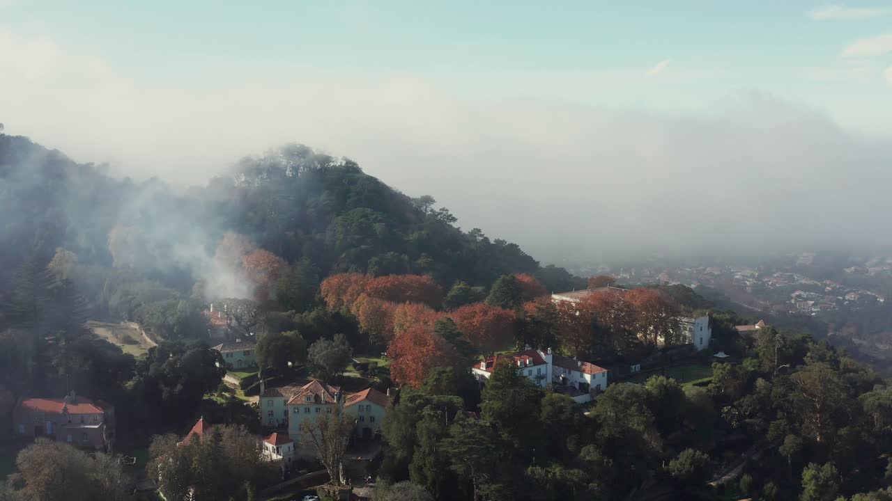 fotografía aérea y de inclinación de una ciudad montañosa nublada en las afueras de sintra, portugal, cerca de lisboa
