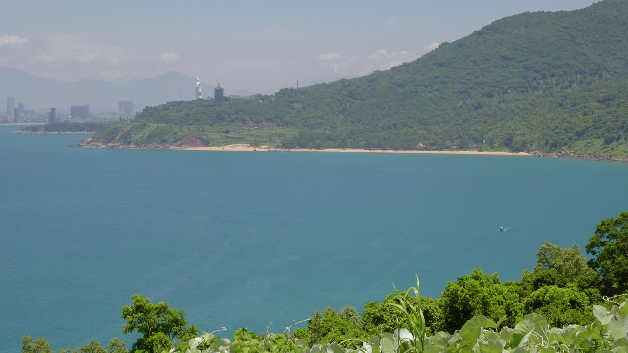The panorama shot of Da Nang taken at midday. It is the largest city in Central Vietnam and a significant port, Da Nang is surrounded by a verdant landscape with hills in the background.