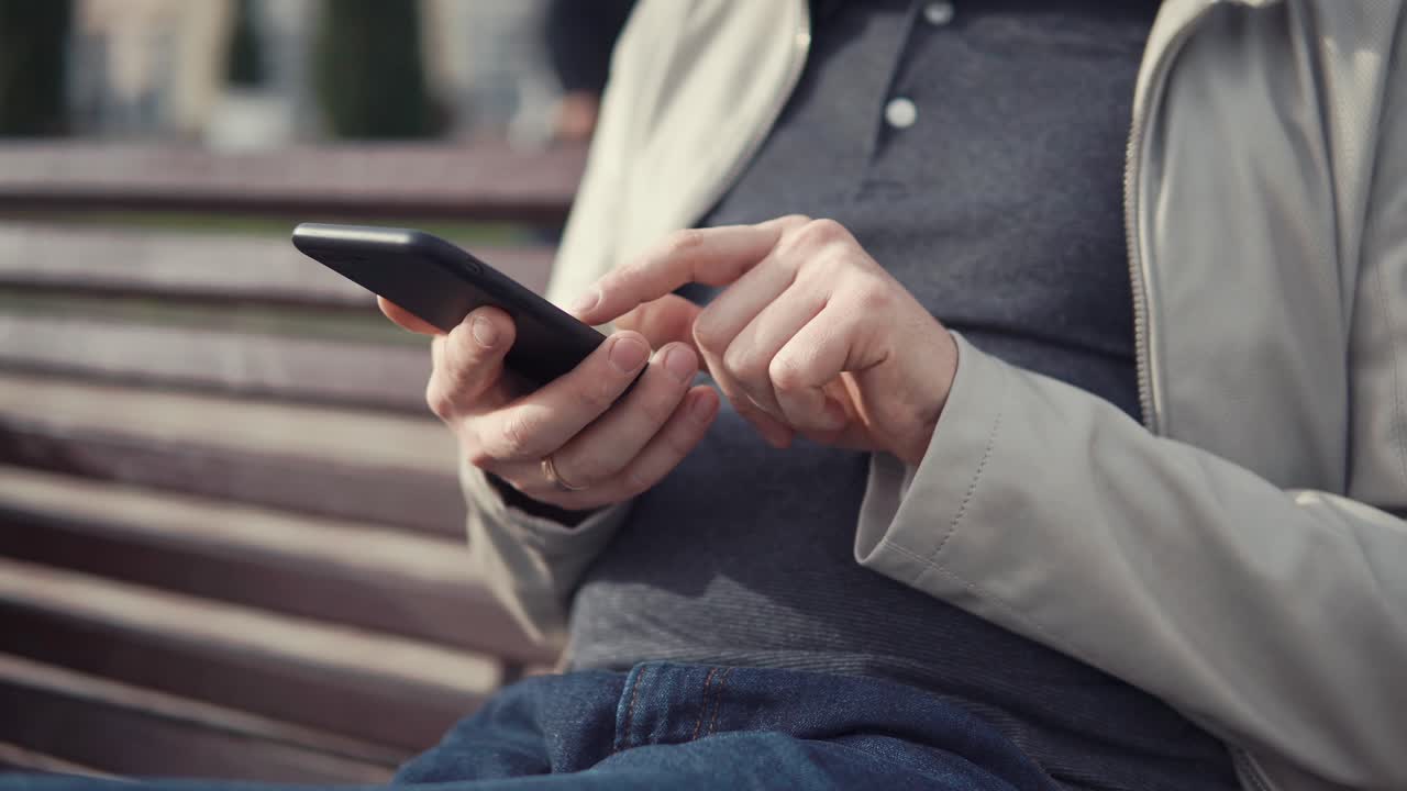 밖에서 스마트폰을 사용하는 남자