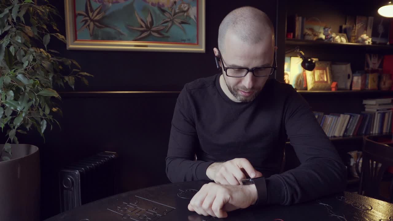 Man looking at his watch in a cafe