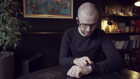 man looking at his watch in a cafe