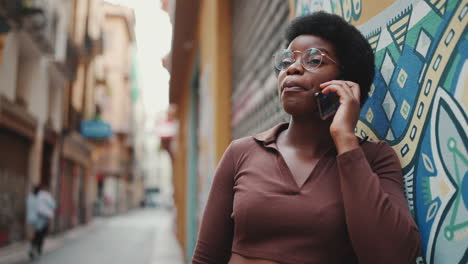 attractive african girl talking over smartphone outdoors