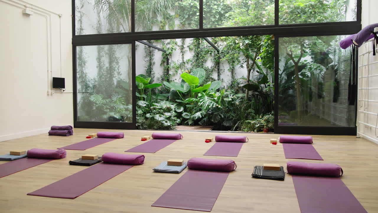 Moderne yoga- og meditationsstudie med naturligt lys og grønne planter