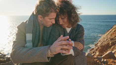 peaceful lovers bonding cliff holding hands at evening closeup. love pair sunset