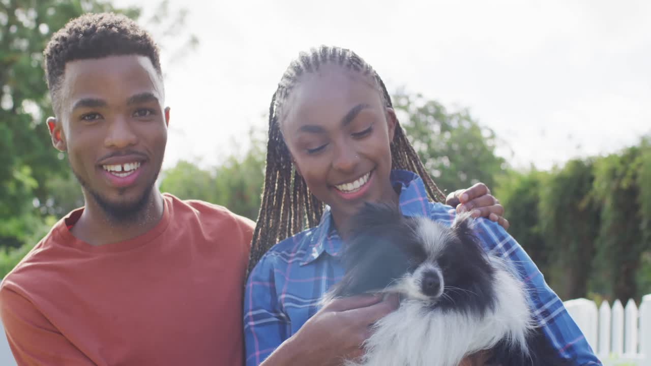 Casal negro feliz com cachorro no quintal.