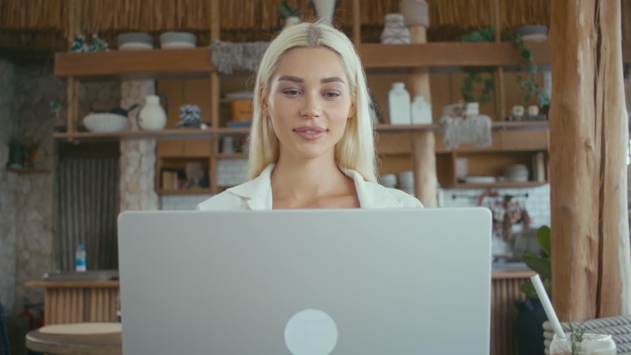 Donna che lavora al computer portatile in un caffè