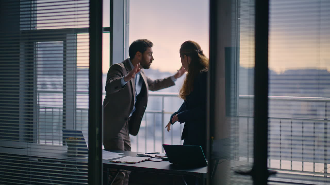 Partner commerciali che litigano in una stanza con finestra e vista sulla città. Il direttore rimprovera il subordinato