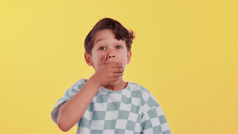 Surprised boy with hand over mouth