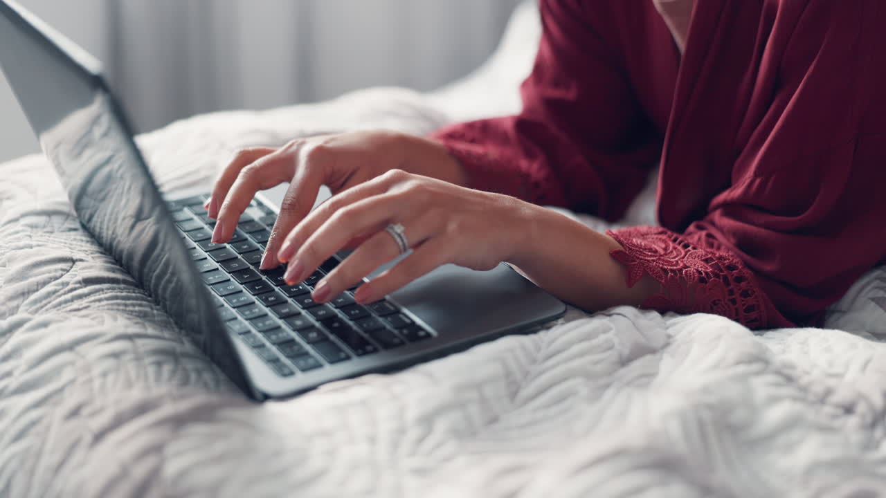 Woman Typing on Laptop in Bed