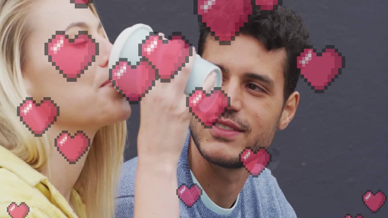 animación de iconos de corazón flotando sobre una feliz pareja caucásica hablando y bebiendo café para llevar
